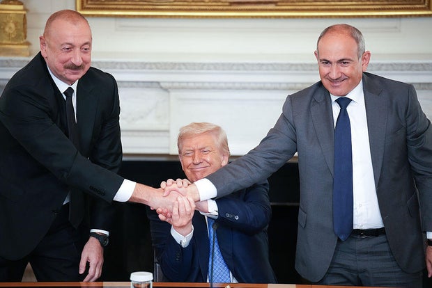President Trump joins hands with Azerbaijani President Ilham Aliyev, left, and Armenian Prime Minister Nikol Pashinyan, right, during a signing ceremony in the East Room of the White House on Aug. 8, 2025. 