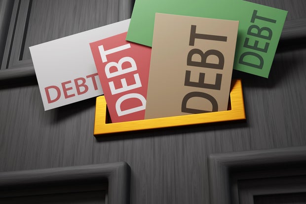 Golden letter plate of a black front door full of colorful letters labelled with the word DEBT. Illustration of the concept of financial loans, overdue payments and bankruptcy 