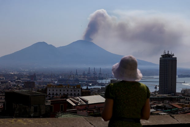 A touritst looks at the smoke of a big fire on Vesuvius 