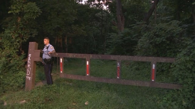 A police officer stands near a fence at Morris Park in West Philadelphia 