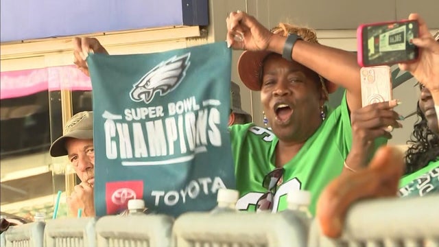 A fan holds up a sign that says Super Bowl Champions beneath the Eagles logo during the open practice 