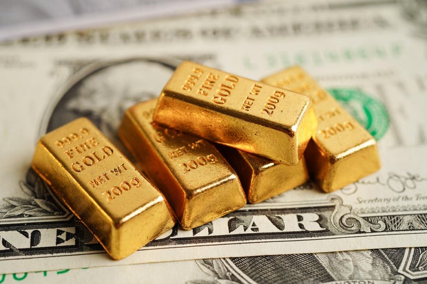 Gold bars on US dollar banknote money, finance trading investment business currency concept. 