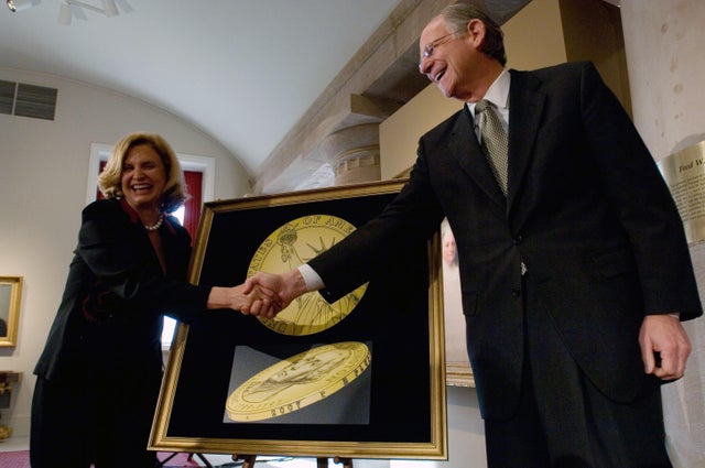 Rep. Michael Castle of Delaware shakes hands with Rep. Carolyn Maloney of New York in front of a drawing representing the "tails" or obverse side of the new presidential $1 coin, during an unveiling ceremony at the National Portrait Gallery on Nov. 20, 2006, in Washington, D.C. 