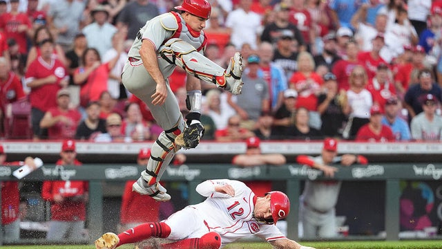 J.T. Realmuto of the Philadelphia Phillies jumps over Austin Hays of the Cincinnati Reds as Hays slides into home plate during the sixth inning at Great American Ball Park 