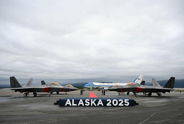 F-22 fighter jets are seen on the tarmac with Air Force One in the distance after President Trump landed at Joint Base Elmendorf-Richardson in Anchorage, Alaska, on August 15, 2025. 