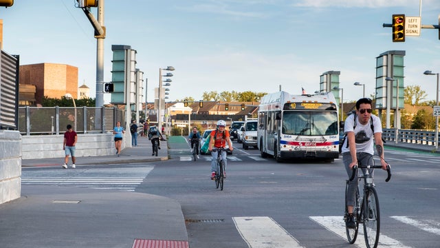 Cyclists commuting on city streets bike lanes with cars and traffic, University City, Philadelphia, Pennsylvania, USA 