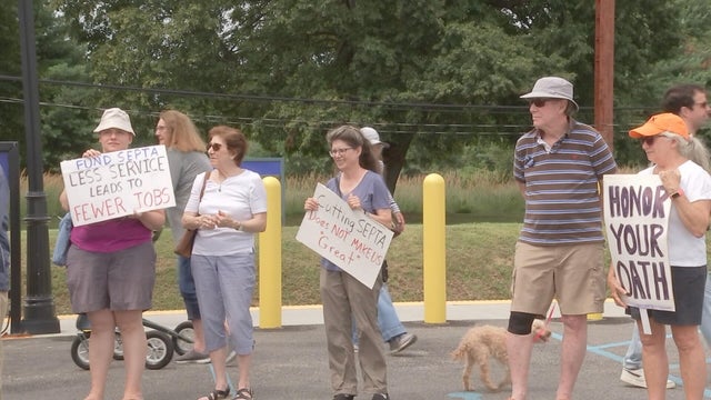 People hold signs during a rally against SEPTA cuts in Warminster, Pennsylvania 