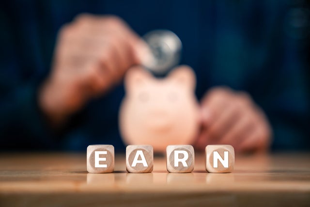 Saving Money, Piggy Bank and Investment Planning with Close-Up of Hand Putting Coins into Piggy Bank 
