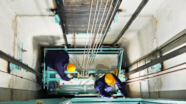 machinist with spanner adjusting lift mechanism 