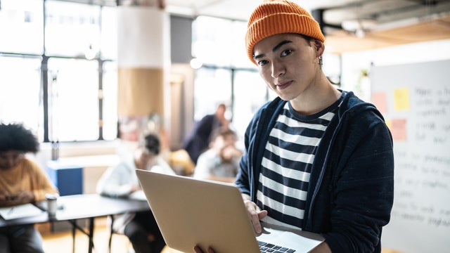Portrait of a young man holding the laptop in the classroom or small business 