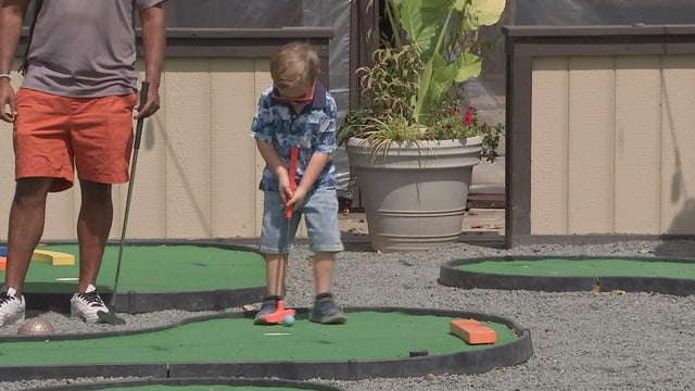 A little boy plays mini golf at Penn's Landing 