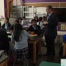 Catholic school students listen to a teacher inside a classroom 