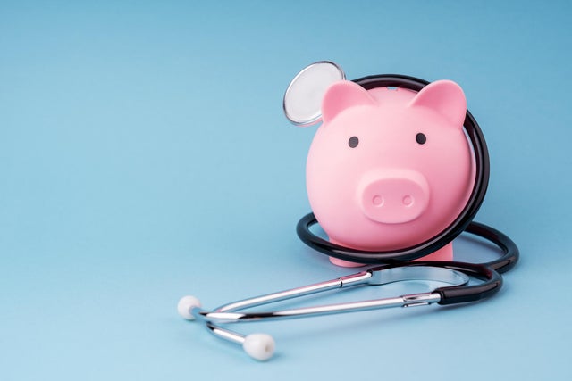 Piggy Bank and Stethoscope on Blue Background 