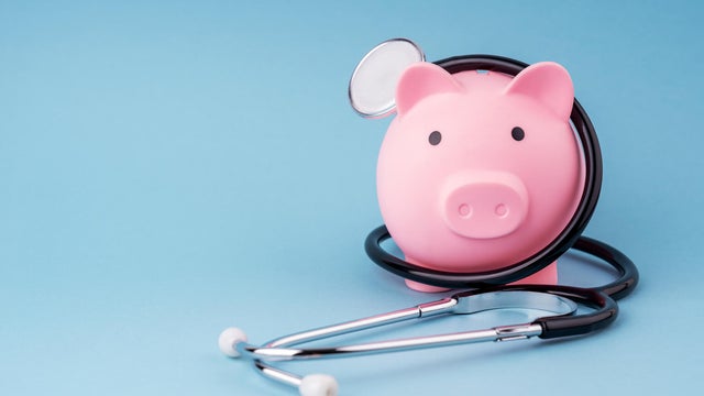 Piggy Bank and Stethoscope on Blue Background 