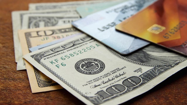 american dollar bills and plastic credit cards on wooden background 