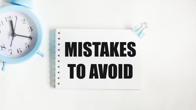 Notepad with text MISTAKES TO AVOID on a white background 