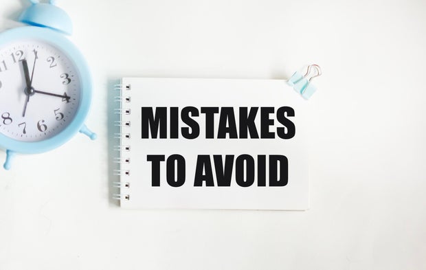 Notepad with text MISTAKES TO AVOID on a white background 