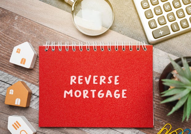 Reverse mortgage concept. Type of loan available to homeowners aged 62 or older, allowing them to convert part of the equity in their home into cash. Business and finance. Notes, inscription, houses 