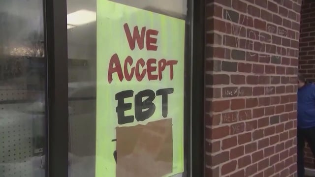 A sign in a store window that says, We accept EBT in all caps 