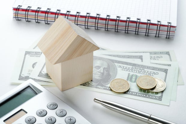 Calculator, Pen, Notepad And Dollar Bills. Layout of a house, real estate. The concept of mortgages, financial accounting of business entities, calculation of business profits or losses, management of expenses and income. Investing, lending and insurance 
