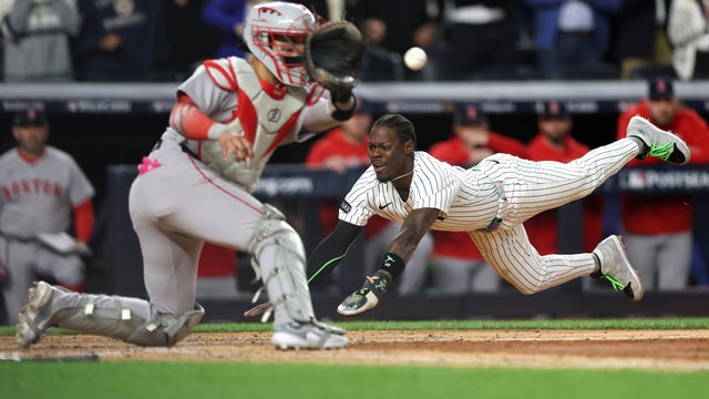 Jazz Chisholm Jr. #13 of the New York Yankees dives into home plate to score a go-ahead run during the eighth inning against the Boston Red Sox in game two of the American League Wild Card Series at Yankee Stadium on October 01, 2025 in the Bronx borough of New York City. 