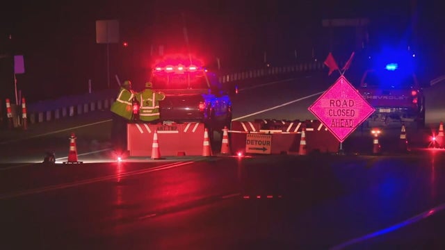 Police lights are seen near a road blockage near the scene of the shooting 