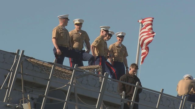 Sailors look out from the ship during the parade on the Delaware River 