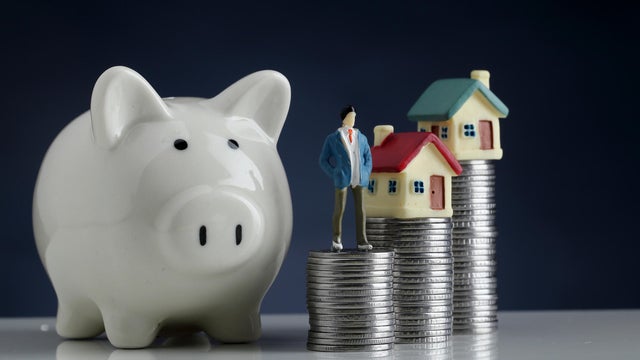 Piggy bank,model house and stack of coins-Concept of money saving 