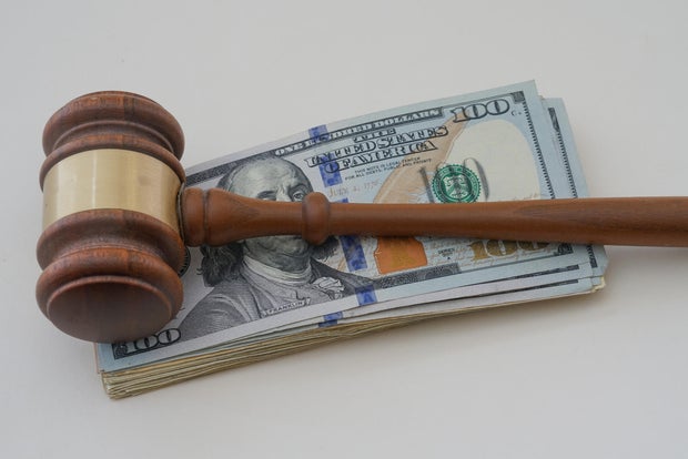 Hammer with money to show a judgment paid with cash