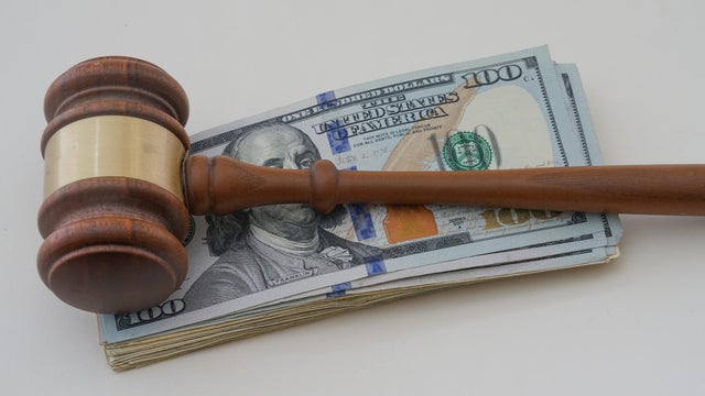 Hammer with money to show a judgment paid with cash 