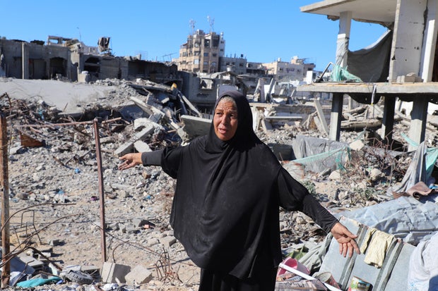 A Palestinian woman, Hayam Meqdad, 49, walks on the rubble of her destroyed home, in Gaza City