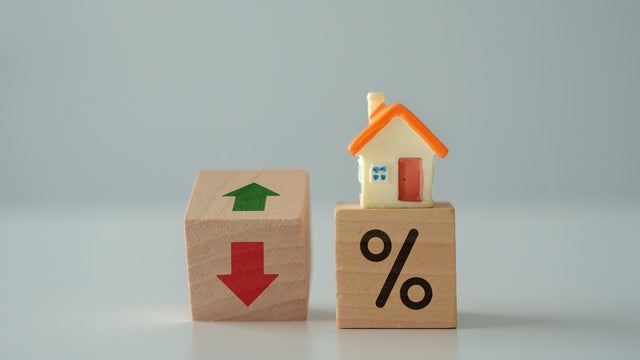 House model and percentage sign with arrow up and down. Housing finance and mortgage rates concept. 