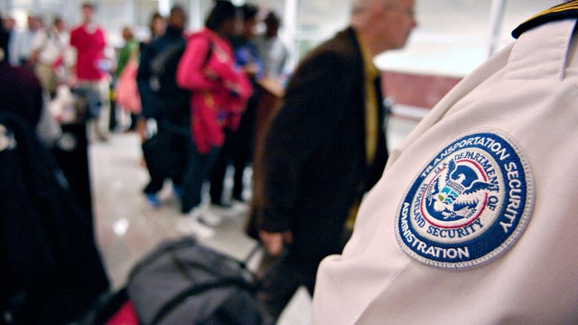 A Transportation Security Administration (TSA) employee stan 