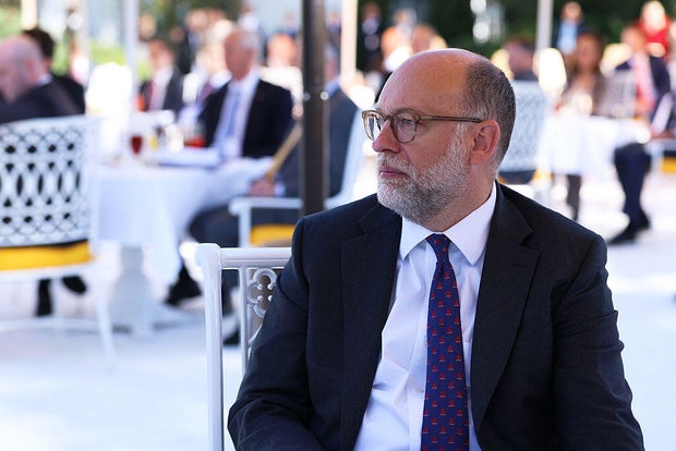 OMB Director Russ Vought listens as President Trump delivers remarks during a luncheon in the Rose Garden of the White House on Oct. 21, 2025.