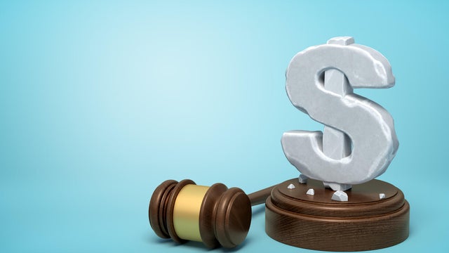 3d rendering of hefty stone dollar symbol standing on wooden sounding block with gavel beside on light-blue background with copy space. 