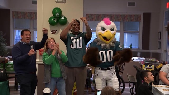 Staff from Ronald McDonald House of Southern New Jersey, Jihaad Campbell and Swoop cheer and dance while singing the Eagles fight song