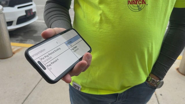 An air traffic controller at PHL shows the pay stub with zero dollars on his phone