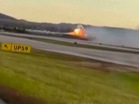 An image capture of video footage distributed by the Associated Press shows flames appearing to come from the left wing of a UPS plane before it crashed in Louisville, Kentucky, Nov. 4, 2025. 