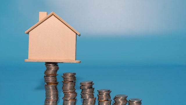 House model on top of coins stacks. Save and investment money concept. 