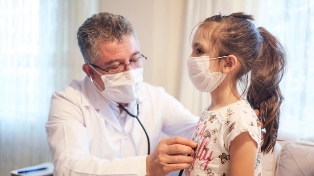 Male doctor examine little patient at home 