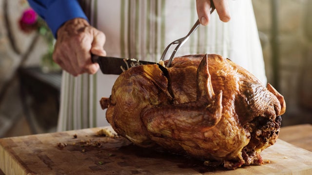 Man carving fresh roasted turkey at home 