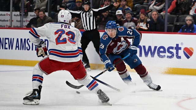New York Rangers defenseman Adam Fox (23), left, and Colorado Avalanche center Nathan MacKinnon (29) battle for the puck during the first period as the Colorado Avalanche take on the New York Rangers at Ball Aren in Denver, Colorado on November 20, 2025. 
