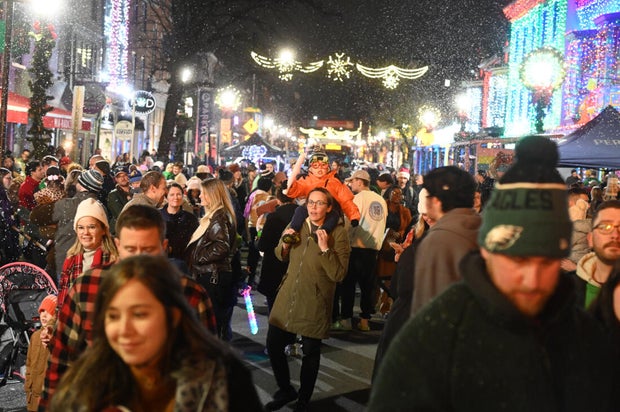 People pose for photos during a holiday event in Manayunk 