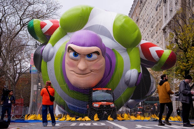 People walk near the new Buzz Lightyear balloon during Macy's Balloon Inflation 2025 on November 26, 2025 in New York City.
