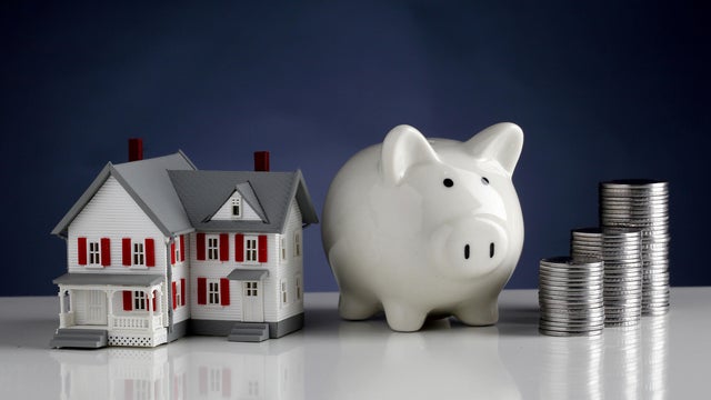 Model house, piggy bank and stack of coins-Concept of money savings 