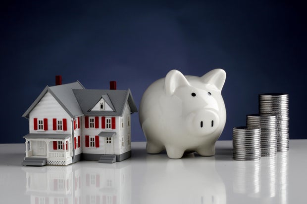 Model house, piggy bank and stack of coins-Concept of money savings 