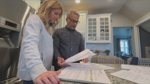 The Hamiltons look at paperwork in their kitchen at home 