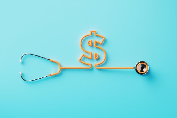 Orange Stethoscope Forming A Dollar Sign On Blue Background 