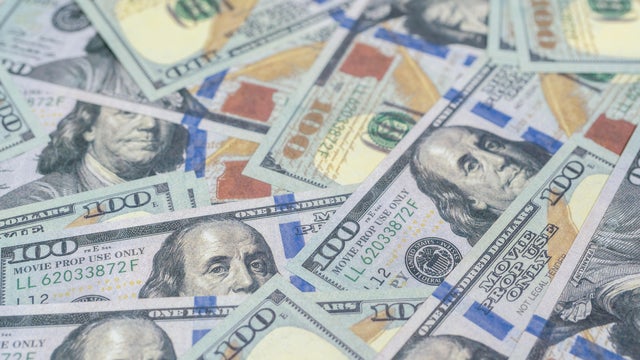 handcuffs sitting on top of US paper currency 