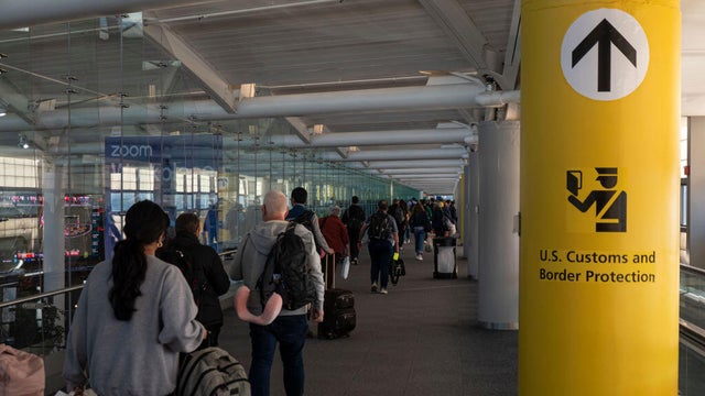 A passenger walks toward immigration control under a U.S. Customs and Border Protection sign at Newark Liberty International Airport in November 2024. 